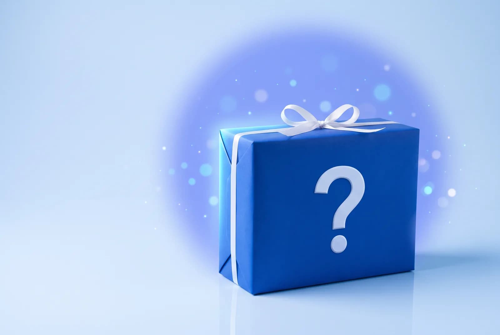Ilustración: caja misteriosa envuelta en papel azul con un signo de interrogación